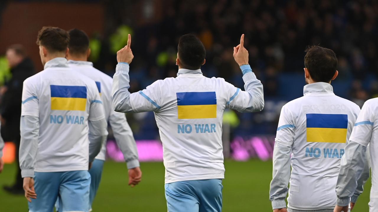 Manchester City players enter the pitch with a Ukrainian flag on their jackets to indicate peace and sympathy with Ukraine. Photo by Michael Regan/Getty Images.