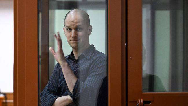 US journalist Evan Gershkovich, accused of espionage, gestures from inside a glass defendants' cage prior to a hearing in Yekaterinburg's Sverdlovsk Regional Court on June 26. Picture: Natalia Kolesnikova/AFP