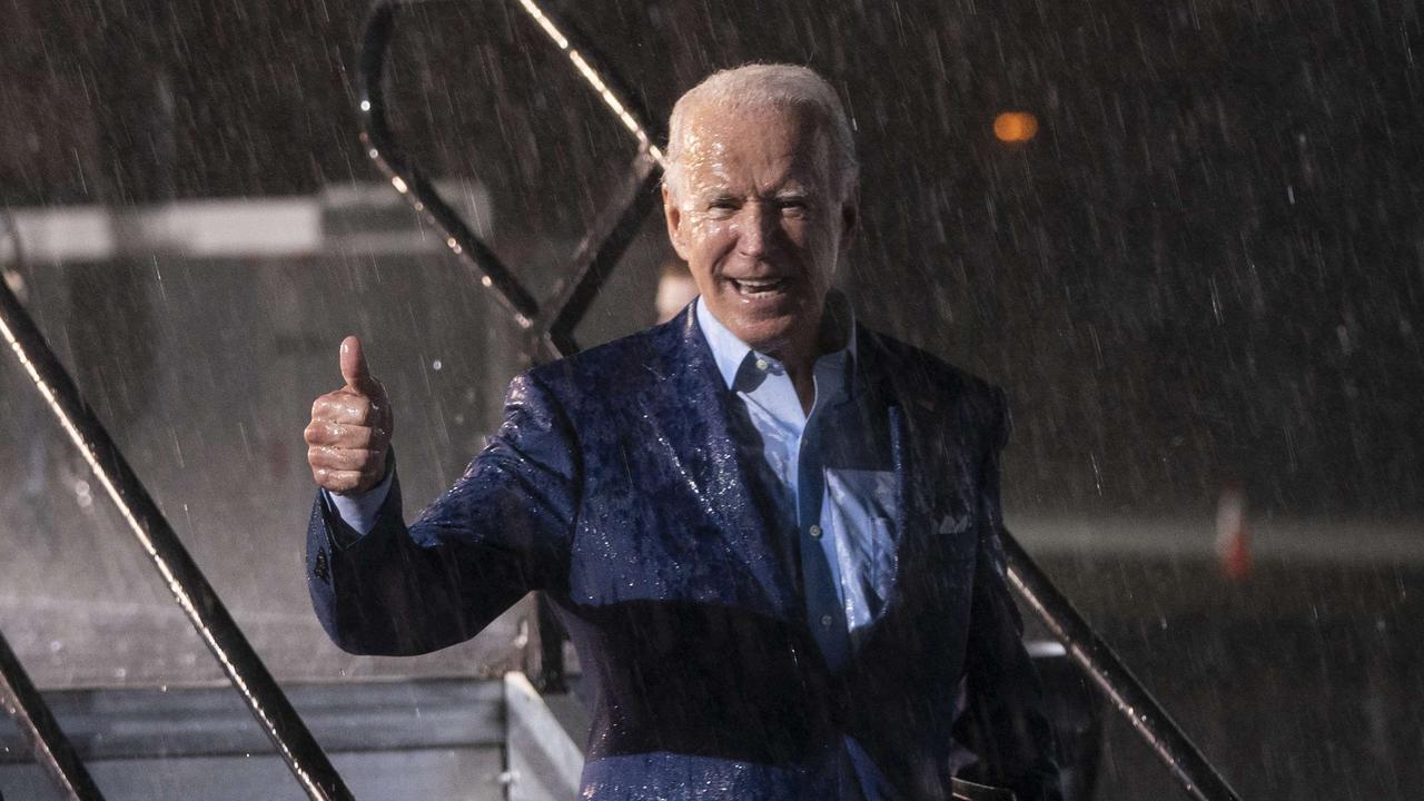 Democratic presidential nominee Joe Biden leaves the stage during a downpour after concluding his remarks at a drive-in campaign rally at the Florida State Fairgrounds. Picture: Drew Angerer/Getty Images/AFP.