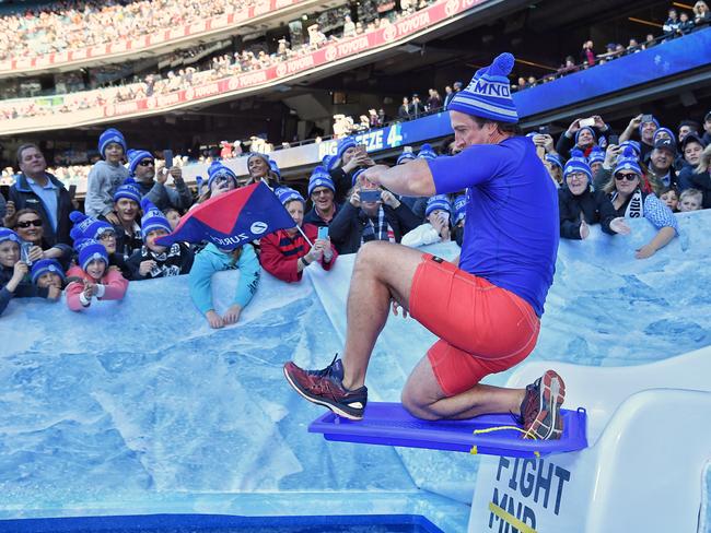 Bulldogs coach Luke Beveridge surfs down the slide. Picture: Jason Edwards