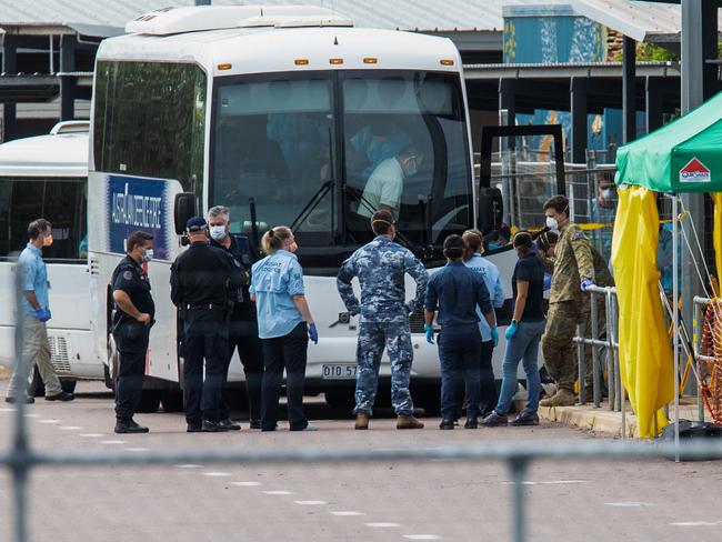 Multiple government agencies gather beside buses to take Australian evacuees from the coronavirus-struck cruise ship Diamond Princess after they arrived on a Qantas flight from Japan at Darwin International Airport in Darwin. Picture: AAP