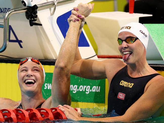 Bronte Campbell raises the arm of sister Cate after Cate broke the Commonwealth 50m freestyle record at the Olympic swimming trials in Adelaide on Thursday night.