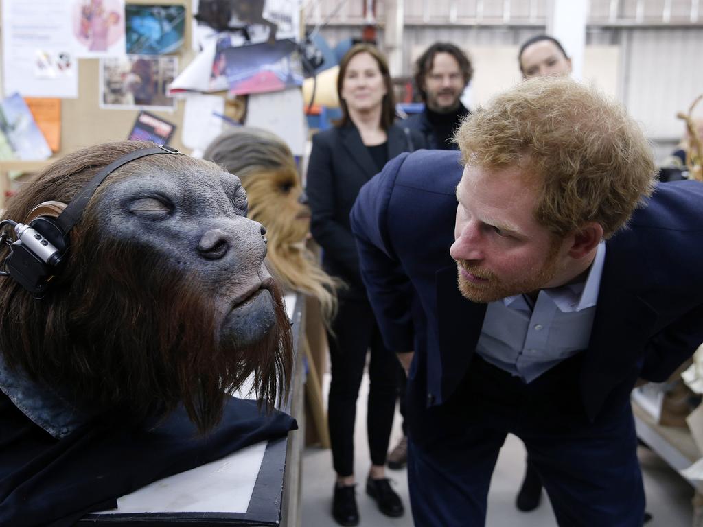 Prince Harry takes a closer look at a robotic mask during a tour of the Star Wars sets at Pinewood studios on April 19, 2016 in Iver Heath, England. Picture: Getty