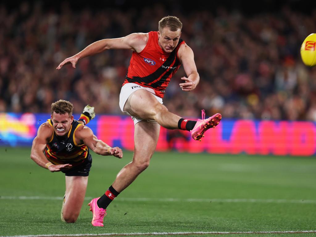 Mason Redman gets a kick away as Mitch Hinge closes in. Picture: James Elsby/AFL Photos via Getty Images