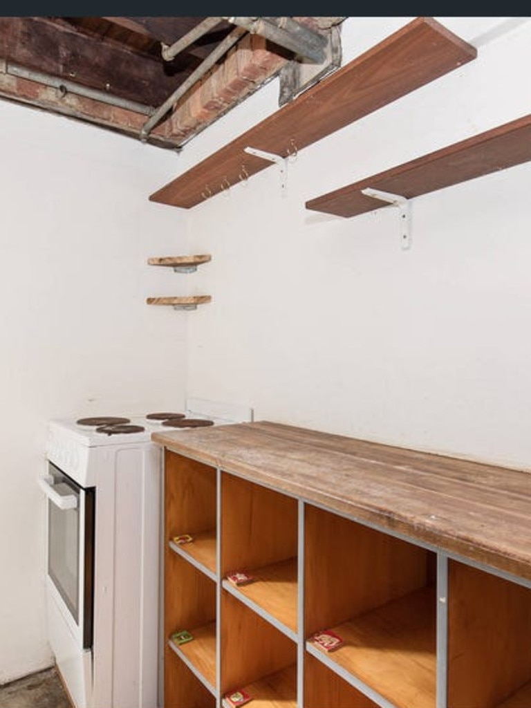 The kitchen space, featuring an alleged gas cooktop, and an exposed ceiling. Picture: Rachel McQueen/TikTok