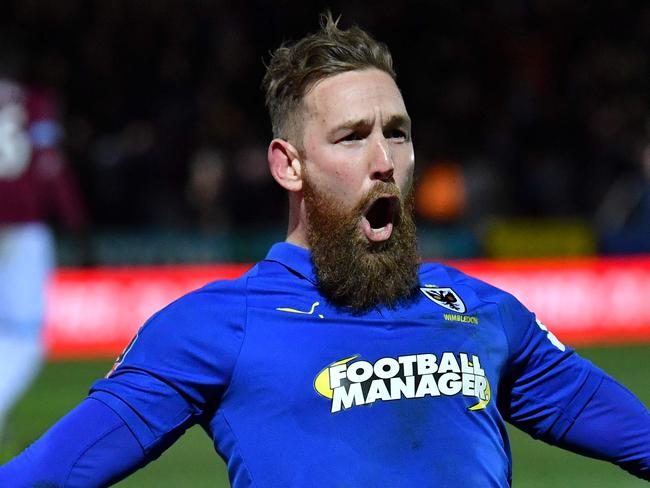AFC Wimbledon's English midfielder Scott Wagstaff celebrates scoring their third goal during the English FA Cup fourth round football match between AFC Wimbledon and West Ham United at Kingsmeadow stadium in London on January 26, 2019. (Photo by Ben STANSALL / AFP) / RESTRICTED TO EDITORIAL USE. No use with unauthorized audio, video, data, fixture lists, club/league logos or 'live' services. Online in-match use limited to 120 images. An additional 40 images may be used in extra time. No video emulation. Social media in-match use limited to 120 images. An additional 40 images may be used in extra time. No use in betting publications, games or single club/league/player publications. /