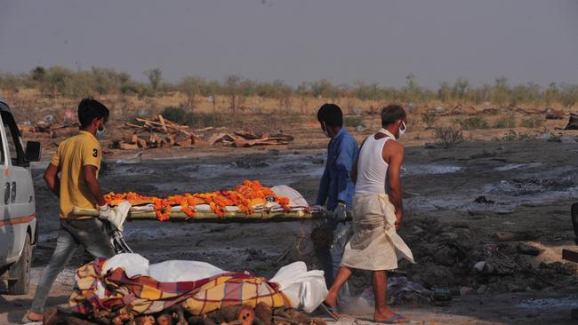 Relatives of a victim who died from Covid perform last rites before cremation, in a mass crematorium ground on the banks of Ganga River in Allahabad, India. Picture: Getty Images