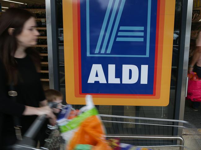 A woman pushes a shoping trolley past an Aldi logo as she leaves one of the company's supermarket stores in London on September 26, 2016. Aldi UK announced on Monday that it will invest £300 million ($389 million, 346 million euros) to revamp its stores over the next three years. Aldi and its German rival Lidl have boomed in Britain, grabbing market share from traditional supermarkets Asda, Morrison, Sainsbury's and Tesco, as customers tightened their belts to save cash. / AFP PHOTO / Daniel Leal-Olivas