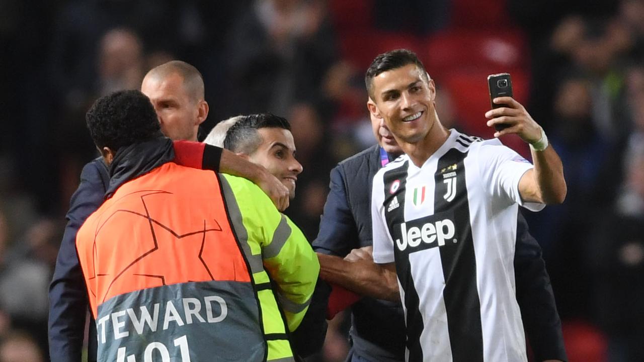 Cristiano Ronaldo of Juventus takes a selfie with a pitch invader