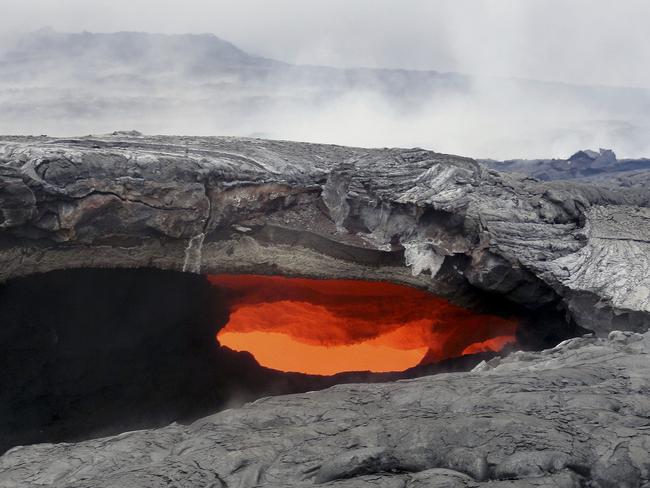 This photo released by the U.S. Geological Survey shows a fluid lava stream within a solidified tube at the Kilauea volcano in Pahoa, Hawaii. Picture: US Geological Survey