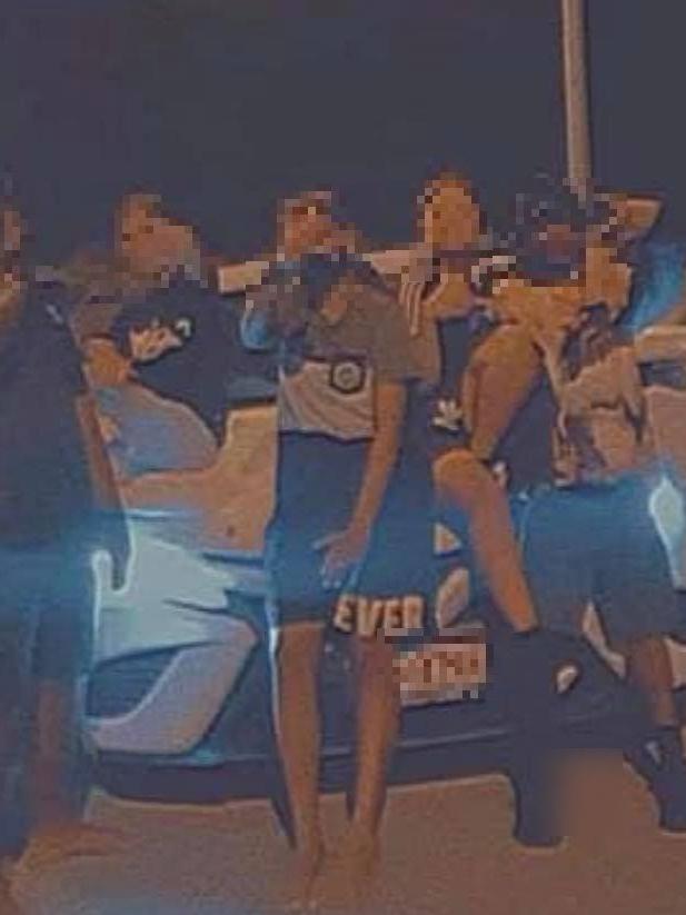 Juveniles pose in front of a stolen car earlier this year.