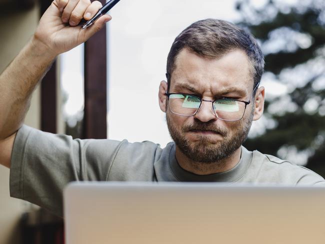 Adult man  in glasses working on laptop outdoors.; angry investor generic money investing