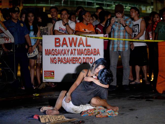 A woman hugs her husband, who was shot dead by an unidentified gunman in Manila on July 23, 2016. Picture: AFP Photo/Noel Celis