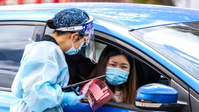 An official takes details at a Covid-19 drive-through testing site at Preston Darebin Arts Centre. Picture: Ian Currie