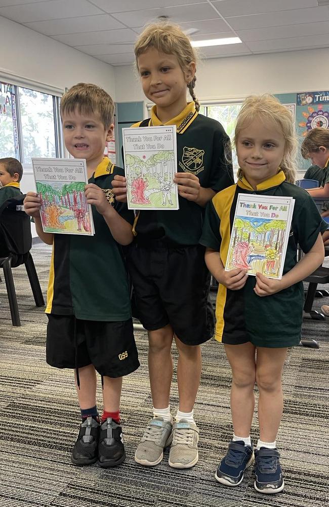 Mitch, Thea and Nora from Goodwood State School stand with their thank you cards for emergency services.