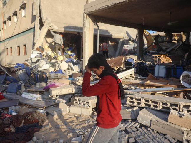 A boy walks on rubble as rescuers search for casualties following an Israeli strike on the municipality building in Deir el-Balah in the central Gaza Strip on December 14. Picture: Eyad Baba/AFP