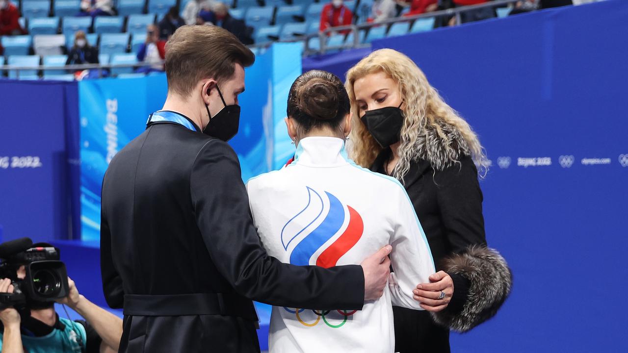 Kamila Valieva is comforted by her choreographer Daniil Gleikhengauz (L) and coach Eteri Tutberidze (R).