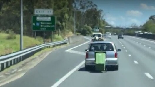 A video shows a car towing a wheelie bin on the M1 in a 110km/h zone at Worongary, Gold Coast.