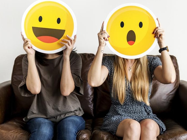 Interracial women holding an expressive emoticon face surprised and happy facial expression social media and chat concept ***These graphics are derived from our own 3D generic designs. They do not infringe on any copyright design.