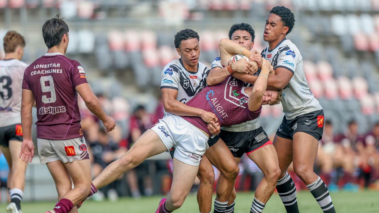 Bailey Trew is wrapped up by Souths Logan.Photography by Stephen Archer.