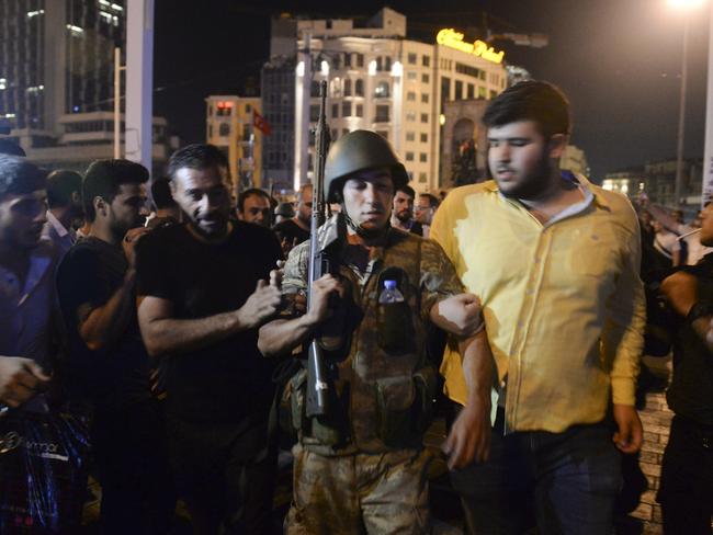 A Turkish soldier, arrested by civilians, is walked over to police officers, in Istanbul's Taksim Square. Picture: Selcuk Samiloglu