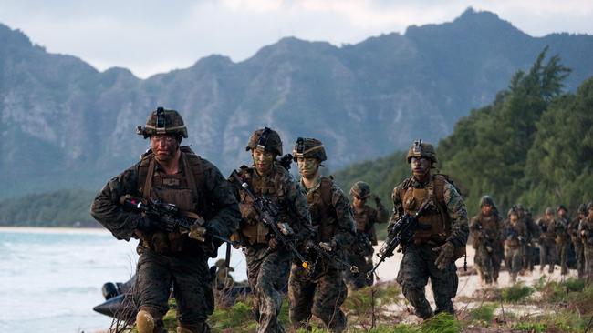 Soldiers of the 2nd Battalion, Royal Australian Regiment, and the United States Marines regroup after an amphibious insertion into Bellows Training Area during Exercise RIMPAC 2018. *** Local Caption *** A multinational amphibious assault on Bellows Beach has marked the final showdown for Exercise Rim of the Pacific (RIMPAC) 2018.   Australian personnel from the 2nd Battalion, Royal Australian Regiment, and US Marine Corps soldiers of Task Force Black’s pre-landing force departed the Royal Australian Navy amphibious ship, HMAS Adelaide, using small-boats to insert onto the beach for an urban raid.   Concurrently, a combat team of follow-on forces launched 13 USMC Amphibious Assault Vehicles from Adelaide’s well dock to storm the beach.  The multinational task force involving soldiers, sailors, airmen and marines from Japan, Tonga, Australia, Indonesia, Malaysia, Sri-Lanka and the United States swiftly executed the amphibious assault by surprising the notional enemy on two fronts.  The  activity was the culmination of weeks of training and preparation conducted during RIMPAC.  RIMPAC is a biennial military training exercise to strengthen international maritime partnerships, enhance interoperability and improve the readiness of participating forces for a wide range of potential scenarios.  The multinational activity, held from 27 June to 2 August 2018 in Hawaii and off the coast of California, is the world’s largest maritime exercise and involves 25,000 personnel from 25 countries.  Participating personnel and assets will conduct gunnery, missile, anti-submarine, and air-defence exercises, as well as maritime interdiction and vessel boarding, explosive ordnance disposal, diving and salvage operations, mine clearance operations and an amphibious landing.