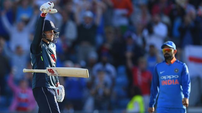 Joe Root celebrates his century off the last ball of a match against India. Virat Kohli looks unimpressed.