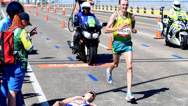 Michael Shelley of Australia (right) passes Callum Hawkins of Scotland as he collapses after being in the lead of the Men's Marathon Final on day eleven of competition at the XXI Commonwealth Games on the Gold Coast, Australia, Sunday, April 15, 2018. (AAP Image/Tracey Nearmy) NO ARCHIVING, EDITORIAL USE ONLY