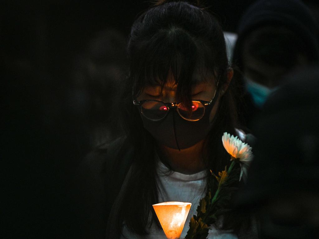 People light candles and hold flowers during a vigil at the Hong Kong University of Science and Technology (HKUST) for student Alex Chow, 22. Picture: AFP