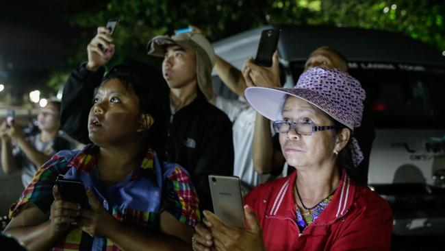 Onlookers watch and cheer as ambulances deliver boys rescued from a cave in northern Thailand to hospital in Chiang Rai. Picture: Getty Images