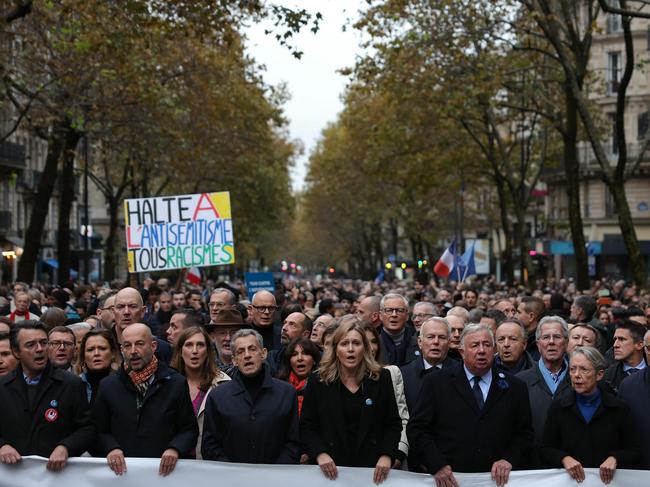 TOPSHOT - French Senate President Gerard Larcher (5thL), President of the French National Assembly Yael Braun-Pivet (4thL), surrounded by French Prime Minister Elisabeth Borne (2ndR), France's former President Nicolas Sarkozy (3rdL) and France's former President Francois Hollande (R) sing the French national anthem as they stand behind a banner which reads as "For The Republic, Against anti-Semistism" during a march against anti-semitism in Paris, on November 12, 2023. Tens of thousands are expected to march Sunday in Paris against anti-Semitism amid bickering by political parties over who should take part and a surge in anti-Semitic incidents across France. Tensions have been rising in the French capital, home to large Jewish and Muslim communities, in the wake of the October 7 attack by Palestinian militant group Hamas on Israel, followed by a month of Israeli bombardment of the Gaza Strip. France has recorded nearly 1250 anti-Semitic acts since the attack. National Assembly speaker Yael Braun-Pivet and Gerard Larcher, the Senate speaker, called on November 7 for a "general mobilisation" at the march against the upsurge in anti-Semitism. (Photo by Thomas SAMSON / AFP)