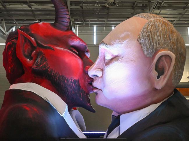 A carnival float featuring Russian President Vladimir Putin kissing a devil is pictured during the presentation of this year's carnival floats of Cologne's carnival committee in Cologne, western Germany, on February 14, 2023. (Photo by INA FASSBENDER / AFP)