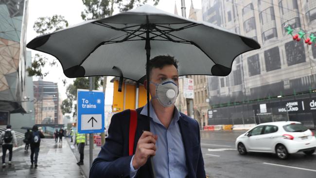 A man covers his face with a mask as air quality levels deteriorate. Picture: David Crosling