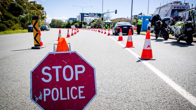 A vehicle stops at a checkpoint on the Pacific Highway on the Queensland-NSW border. (Photo by Patrick HAMILTON / AFP)