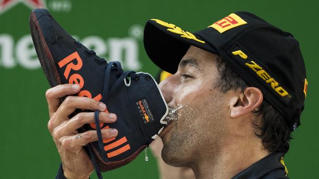 TOPSHOT - Red Bull's Australian driver Daniel Ricciardo drinks champagne out of his shoe as he celebrates on the podium after winning the Formula One Chinese Grand Prix in Shanghai on April 15, 2018. / AFP PHOTO / Johannes EISELE