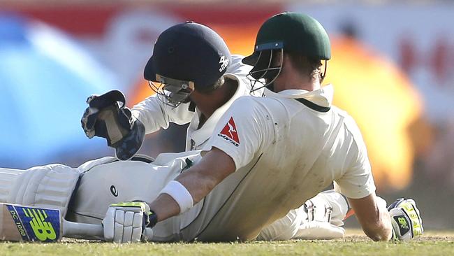 Wriddhiman Saha attempts to take the ball stuck in between the legs of Steven Smith.