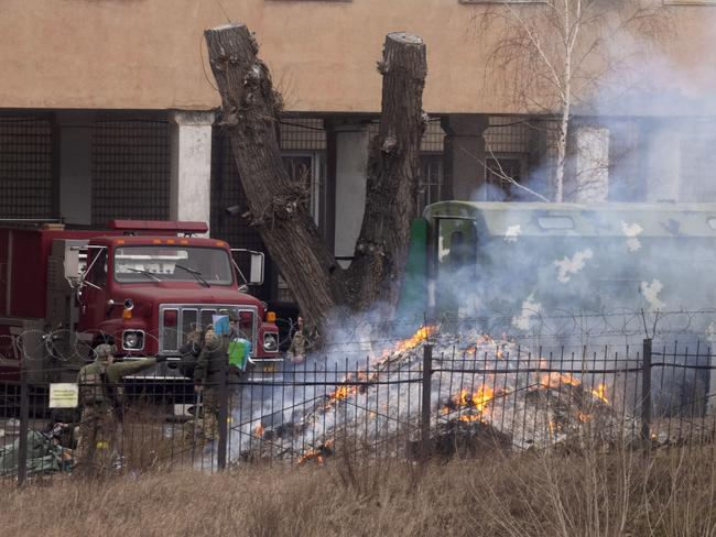 Military personnel throw items into a fire outside an intelligence building as Russia began its large-scale attack. Picture: Getty