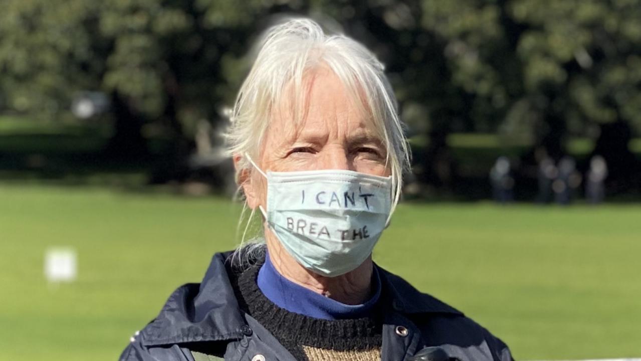 One protester with a mask that reads ‘I can’t breathe’. She stood with a man holding a sign protesting Australia’s treatment of refugees. Picture: NCA NewsWire/Hannah Moore