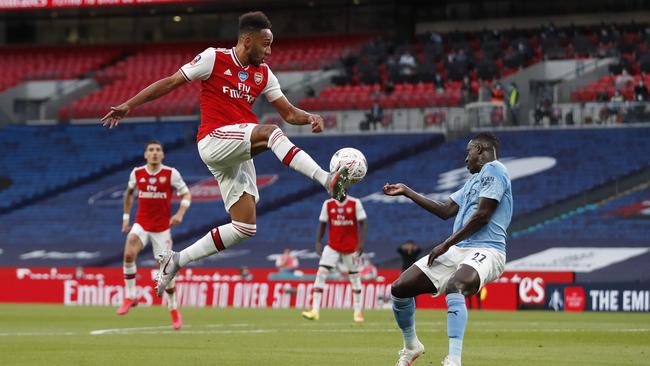 Arsenal’s Pierre-Emerick Aubameyang jumps for the ball in front of Benjamin Mendy at Wembley Stadium. Picture: Getty