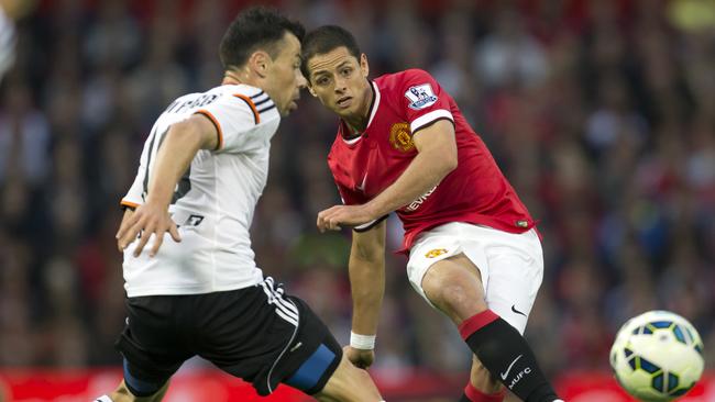 FILE - This is a Tuesday Aug. 12, 2014 file photo of Manchester United's Javier Hernandez as he fires a shot past Valencia's Javi Fuego during a pre season friendly soccer match at Old Trafford Stadium, Manchester, England. Real Madrid has signed Mexico striker Javier Hernandez on a season-long loan from Manchester United. Madrid announced the deal hours before the close of the summer transfer window on Monday Sept. 1, 2014. (AP Photo/Jon Super, File)