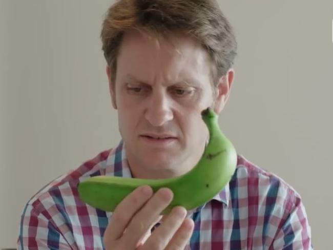 Craig Reucassel with a banana that was considered too curved to be sold in a supermarket.