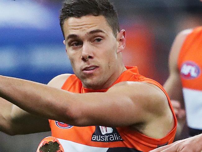 Giants Josh Kelly kicks ahead Hawthorn's Luke Breust during AFL match between the GWS Giants and Hawthorn at Spotless Stadium, Sydney. Picture. Phil Hillyard