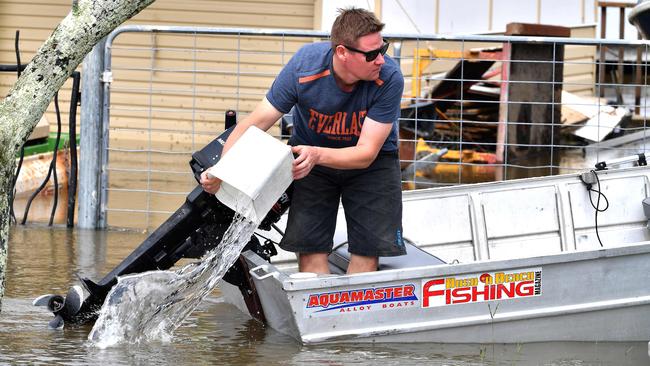 A man removes water from his boat before visiting a flood affected neighbourhood in Lawrence. Photo: SAEED KHAN / AFP