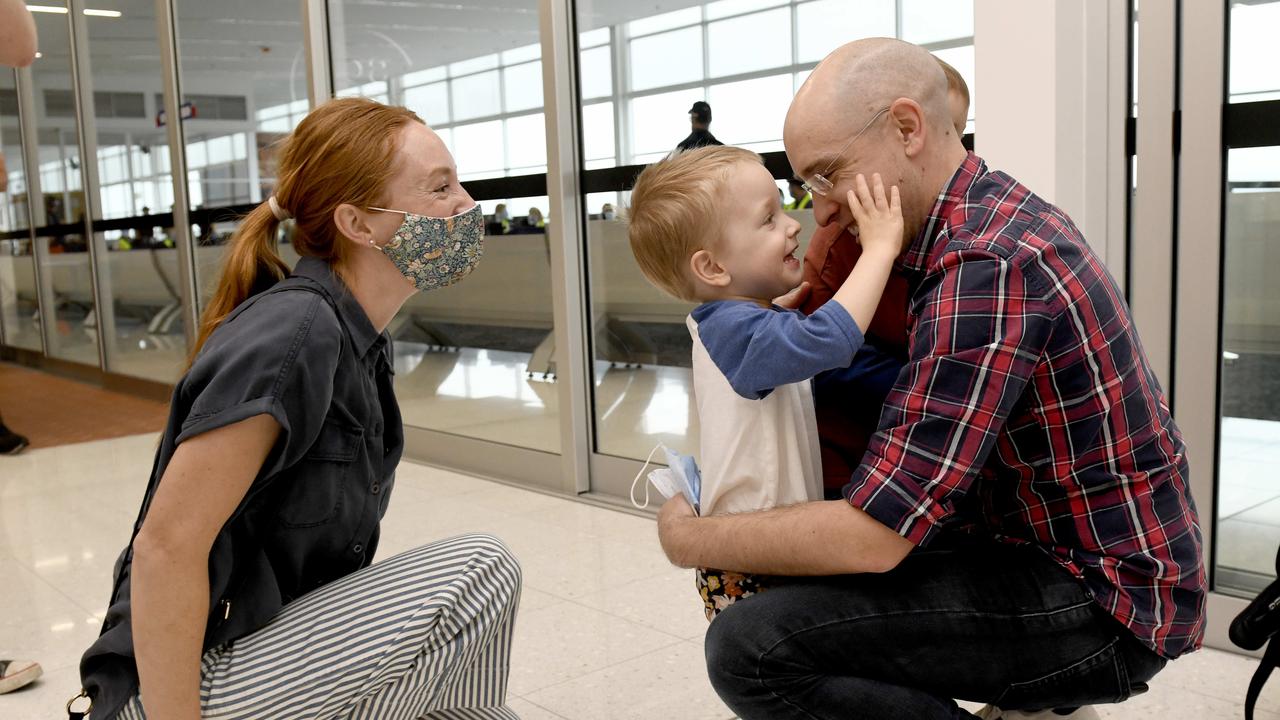 The first flight from Melbourne at Adelaide Airport.: Adam Nelson is reunited with wife Ellie Nelson and sons Max (closest to camera) and Archer. Picture: Naomi Jellico