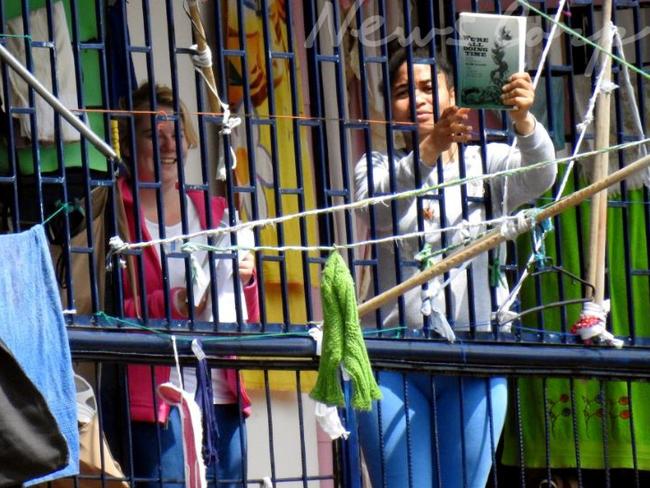 Cassie Sainsbury and a fellow prisoner, who can be seen holding up a book entitled ‘We’re all doing Time’. Picture: Nathan Edwards