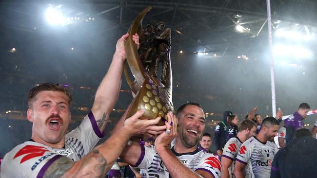 Cameron Munster and Cameron Smith of the Storm pose with the premiership trophy.