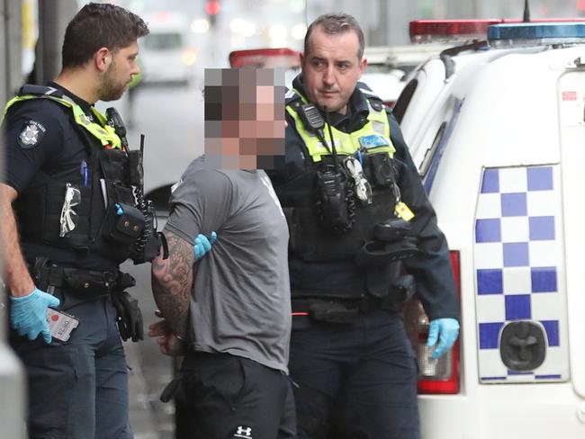 Police take a man into custody outside Flinders st Station. Monday, July 29. 2024. Picture: David Crosling