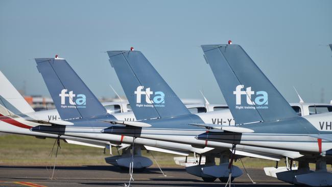 Australian Transport Safety Bureau officers inspect the wing of a Flight Training Adelaide Socata TB-10 aircraft at Parafield Airport, Wednesday, July 12, 2017. The aircraft made an emergency landing after reportedly hitting a drone. (AAP Image/Brenton Edwards)