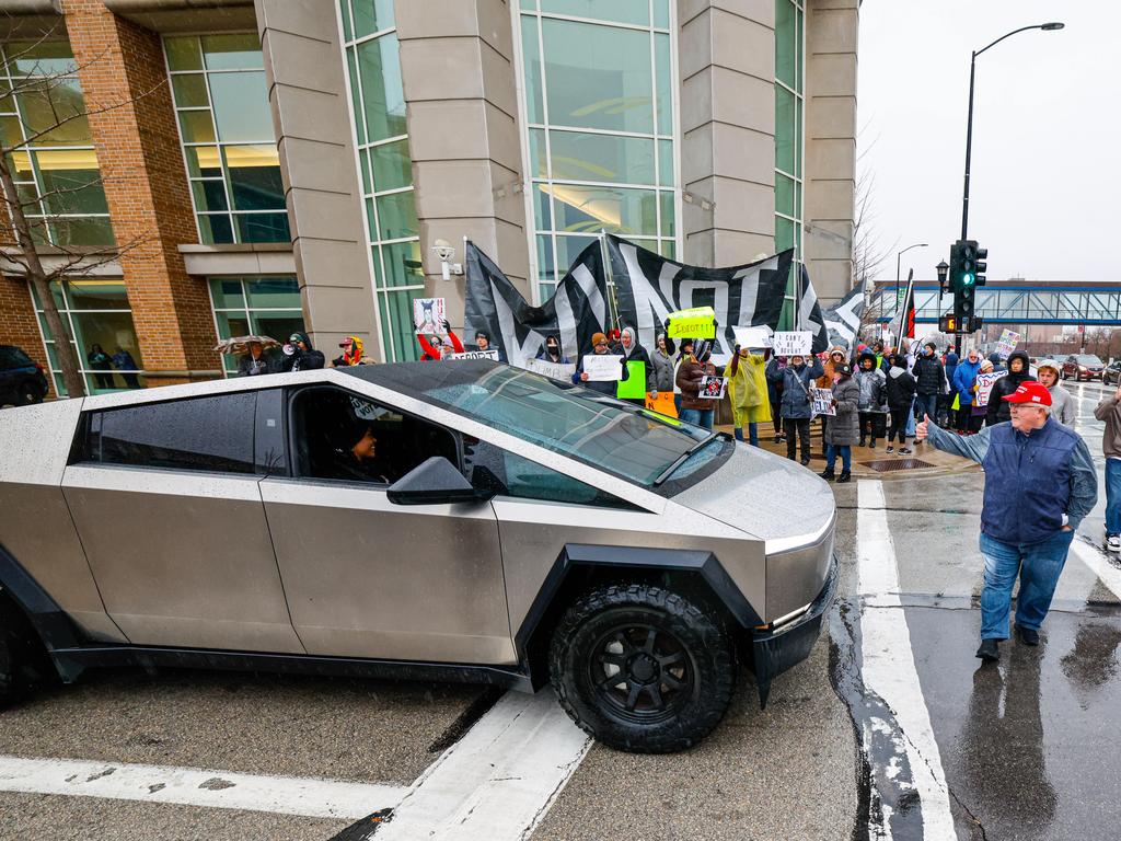 Protesters shout at a Tesla Cybertruck as people begin to arrive for a town hall with Elon Musk in Green Bay, Wisconsin. Picture: AP