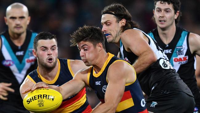 Kyle Hartigan of the Crows is tackled by Jarrod Lienert of the Power. Picture: AAP Image/David Mariuz